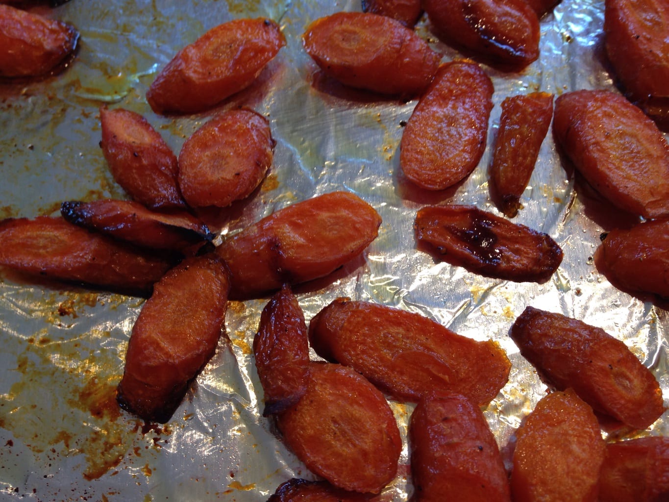 Honey roasted carrots on a foil-lined cookie sheet.