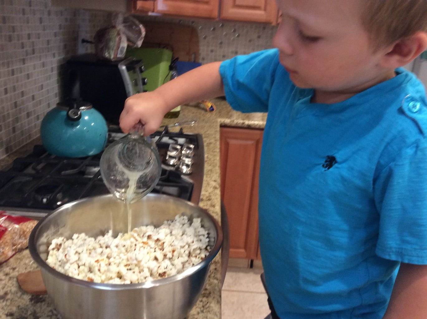 Kids cook popcorn at home in a popcorn maker Stock Photo