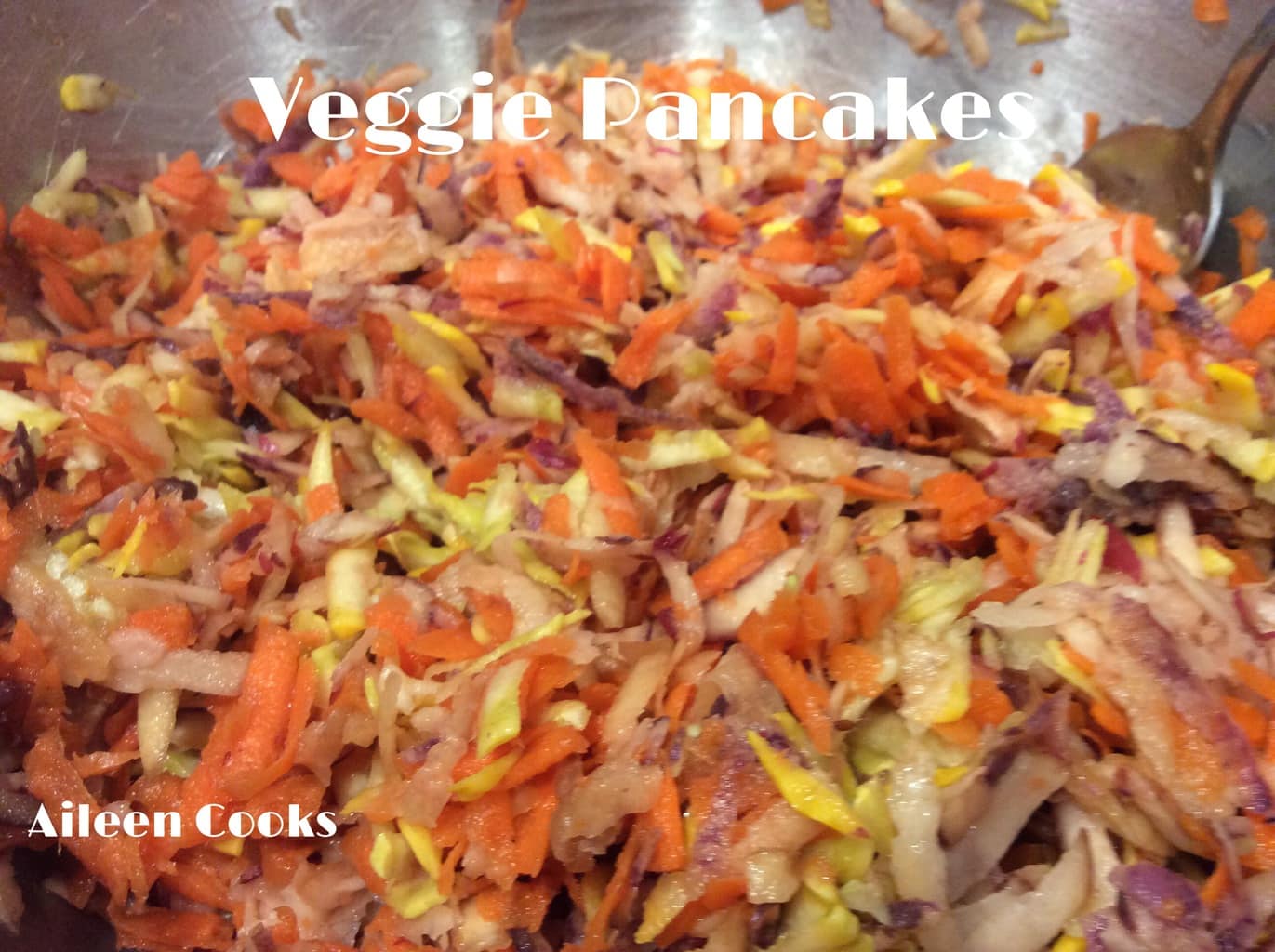 Shredded vegetables in a bowl, ready to be made into veggie fritters.