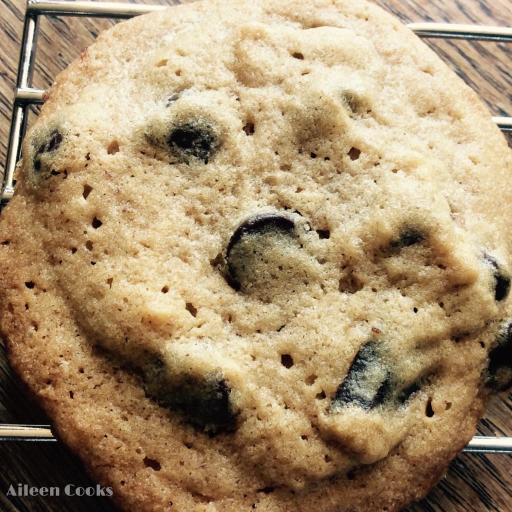 Close up of a peanut butter chocolate chunk cookie on a cooling rack.