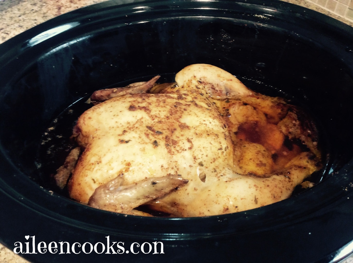 A whole chicken sitting inside of a crockpot.