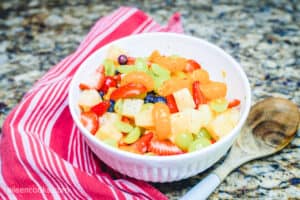 A large white bowl filled with fruit salad.