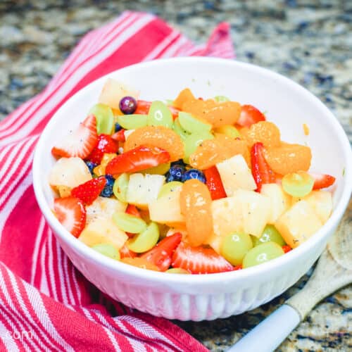 A large white bowl filled with fruit salad.