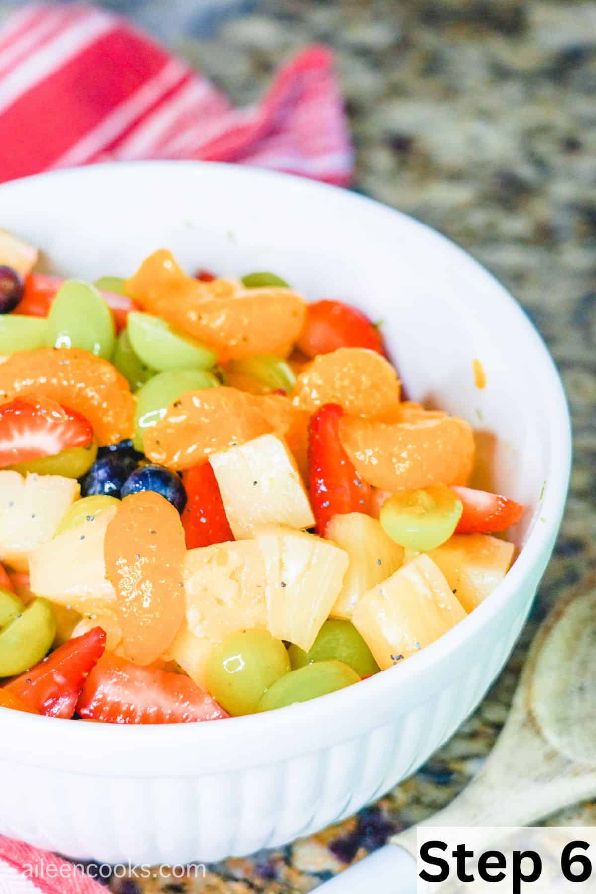 A bowl of fruit salad tossed in honey lime dressing.