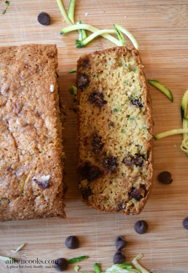 Whole wheat zucchini bread on a wooden cutting board cut into slices. 