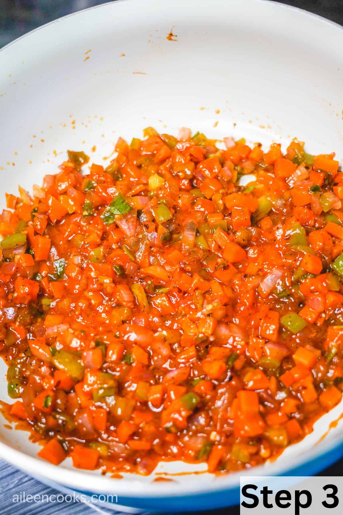 Cooked vegetables coated in spices, ketchup, and Worcestershire sauce in a large skillet.