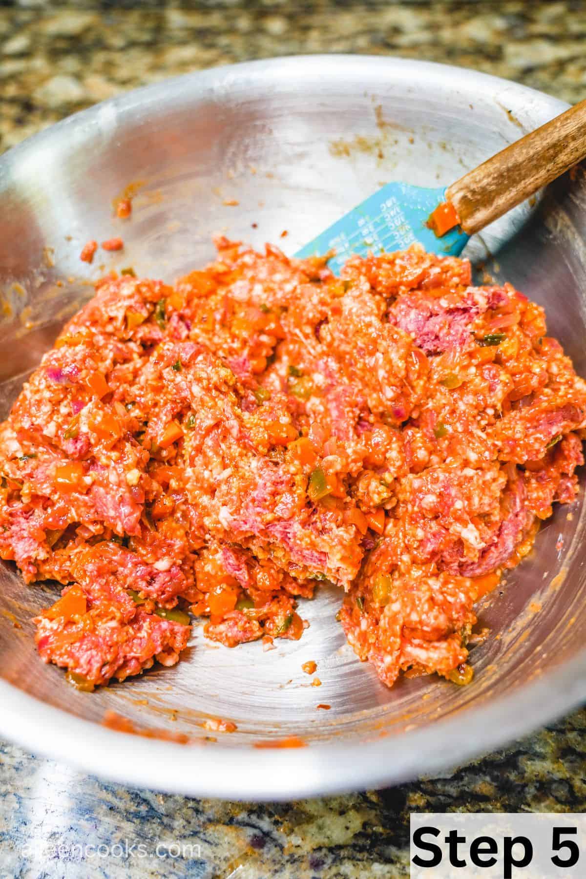 Meatloaf ingredients mixed together in a large metal mixing bowl.