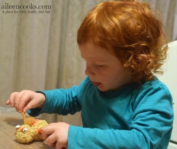 Fun and festive rice krispie treat snowmen made with rice krispies, cocoa krispies, and holiday rice krispies. Such a fun christmas tradition! Cooking With Kids Recipe from aileencooks.com #ad