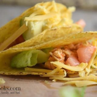 instant pot salsa chicken tacos in crispy taco shells with fresh tomato and lettuce