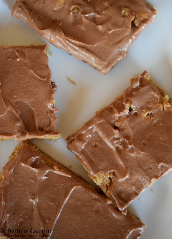 Peanut Butter Bars with Chocolate Frosting made with a chewy peanut butter cookie base, natural peanut butter, and creamy chocolate frosting. You even get to sneak some whole grains into your kid's diet with this recipe! Recipe for Peanut Butter Bars with Chocolate Frosting from aileencooks.com