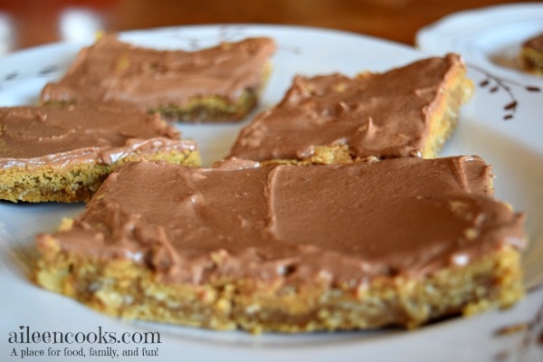 Peanut Butter Bars with Chocolate Frosting made with a chewy peanut butter cookie base, natural peanut butter, and creamy chocolate frosting. You even get to sneak some whole grains into your kid's diet with this recipe! Recipe for Peanut Butter Bars with Chocolate Frosting from aileencooks.com