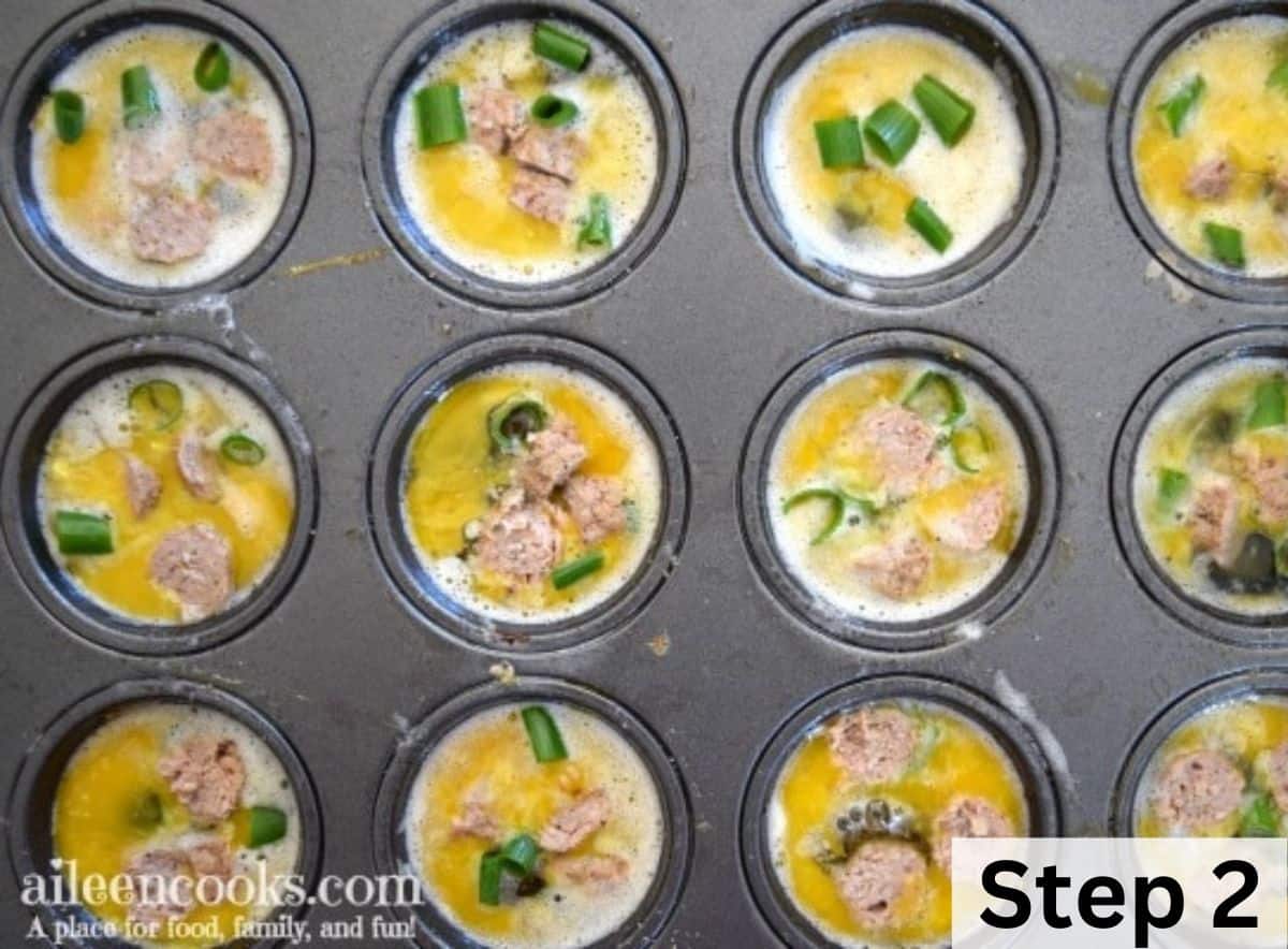 A muffin tin filled with raw eggs, turkey sausage, and sliced green onions.