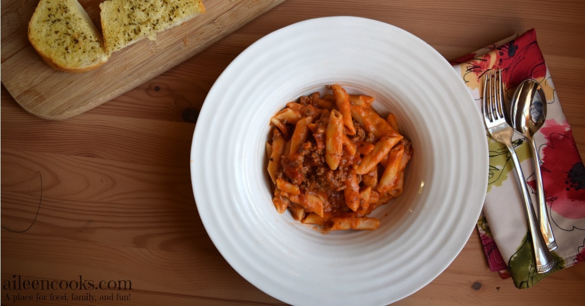 Pressure cooker baked ziti served in a large rimmed white bowl. 