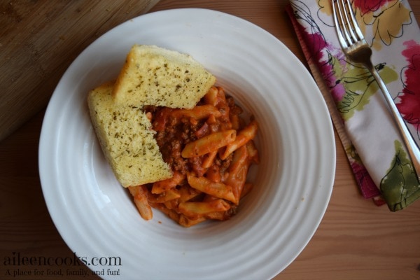 Instant Penne Pasta shown served as baked ziti with two slices of garlic bread.