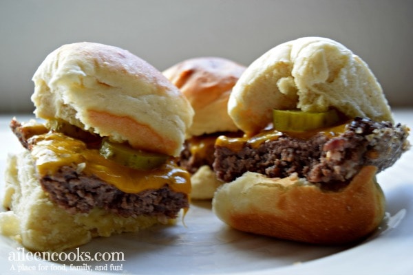 Side view of easy cheeseburger sliders with pickles and ketchup.