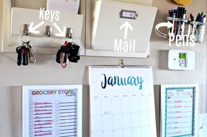 Command center with mail slots, key hooks, mason jars holding pens, and picture frames holding a meal and a grocery list.