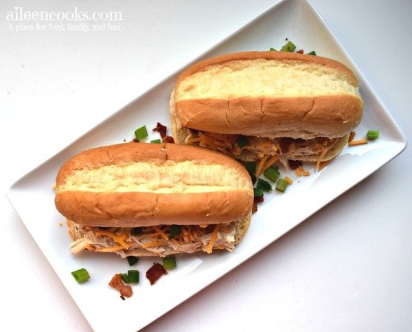 White platter with two instant pot crack chicken sandwiches.