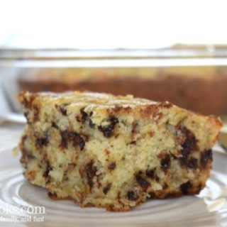 close up of slice of banana chocolate chip cake with whole cake in the background