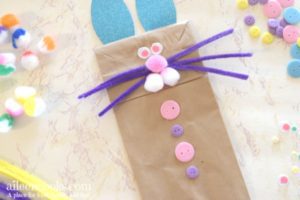 easter bunny hand puppet made with paper lunch bag, buttons, pipe cleanrs, and cotton balls.
