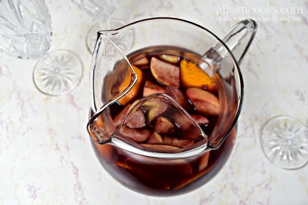 pitcher of red wine sangria with chopped apples and oranges.