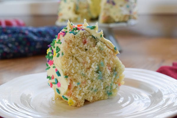 slice of instant pot cake with full bundt cake in background.