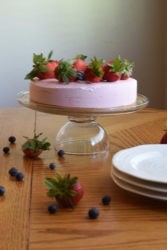no-bake strawberry cheesecake on glass cake stand
