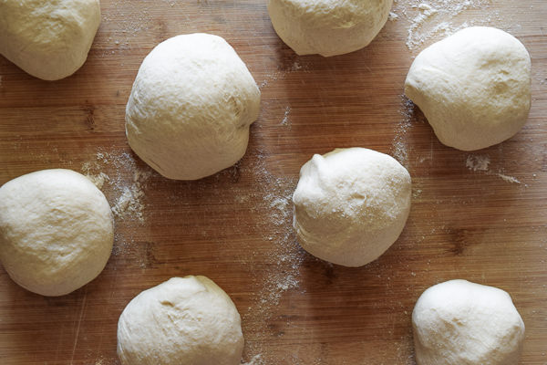 8 balls of pizza dough ready to be rolled out for homemade frozen pizzas. 