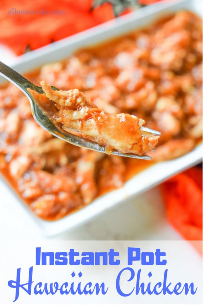 Close up of instant pot hawaiian chicken on a fork with dish of chicken in the background.