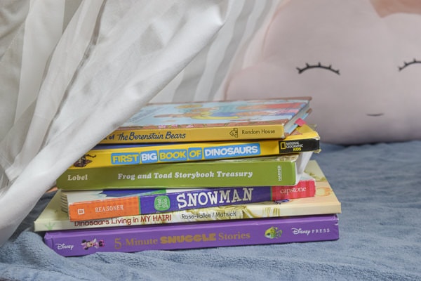 Stack of colorful books inside a reading nook.