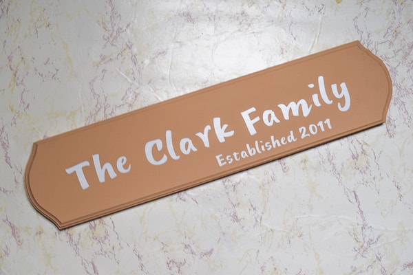 Established family name sign painted beige with white vinyl letters on top that were cut with the cricut maker.