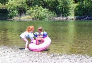 Two girls and a pink inner tube ready to swim in the Russian River.