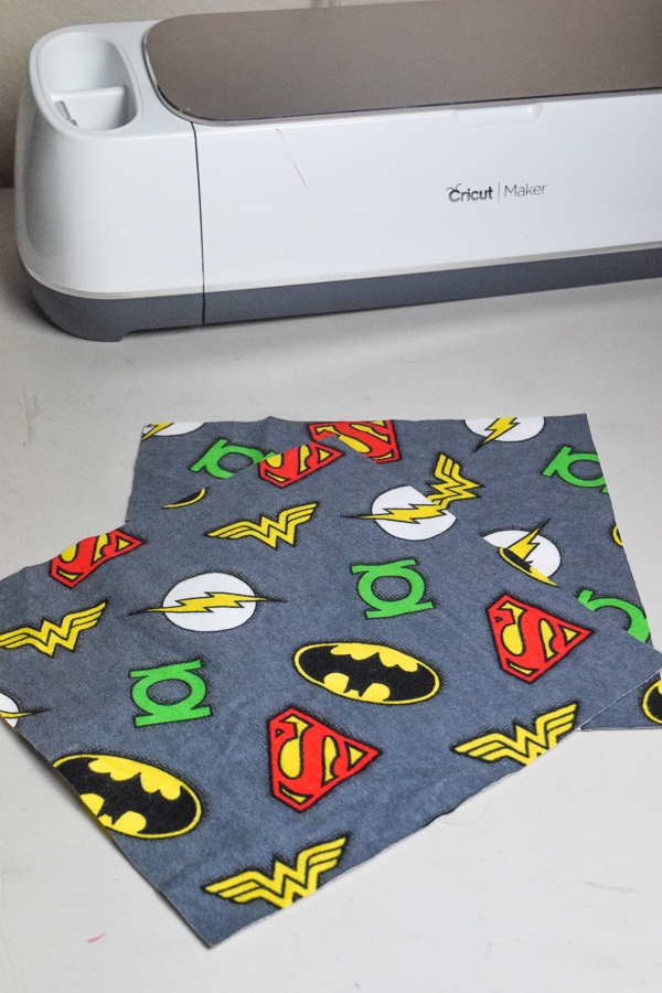 Grey super hero fabric cut into squares and ready to be made into a tooth fairy pillow.