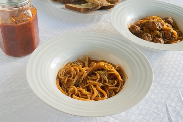 A bowl of cooked spaghetti topped in pressure cooker spaghetti sauce.