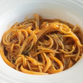 Close up of instant pot spaghetti sauce with a fresh batch of spaghetti.