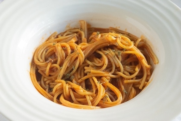 Close up of instant pot spaghetti sauce with a fresh batch of spaghetti.