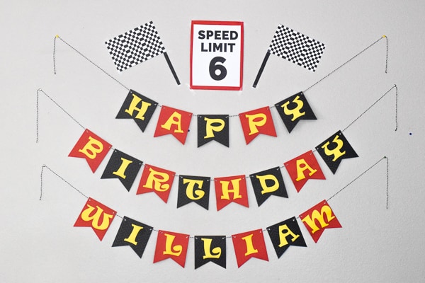Happy Birthday William banner with a Speed Limit 6 sign and two checkered flags - all made out of paper.
