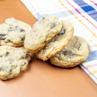 Knocked over stack of salted chocolate chip cookies on a plaid dish towel.