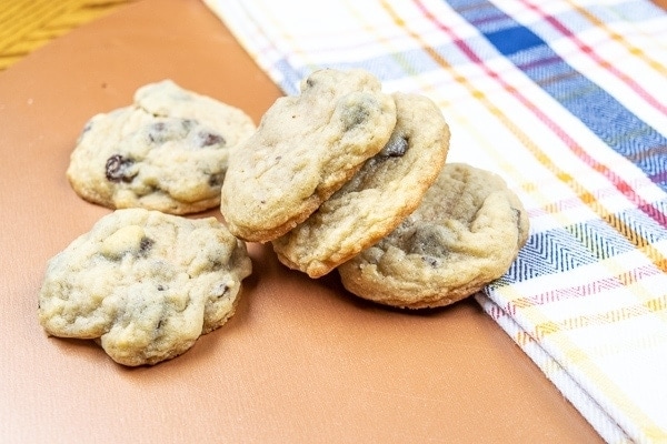 Knocked over stack of salted chocolate chip cookies on a plaid dish towel.