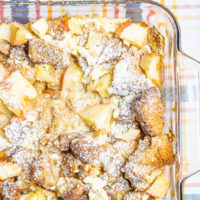 Apple-cinnamon french toast bake prepared in a glass baking dish and placed on a plaid tablecloth.