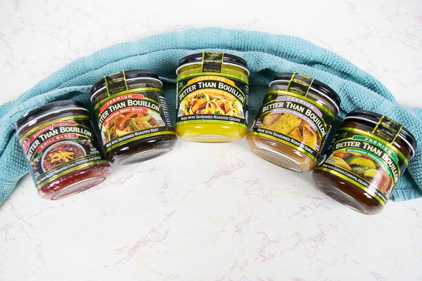 Several Better Than Bouillon flavors lined up on a blue kitchen towel.