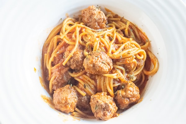Instant pot spaghetti and meatballs served in a white wide rimmed bowl.