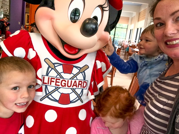 A group selfie of a mom, her three children, and Minnie mouse at a Disneyland Character Breakfast.