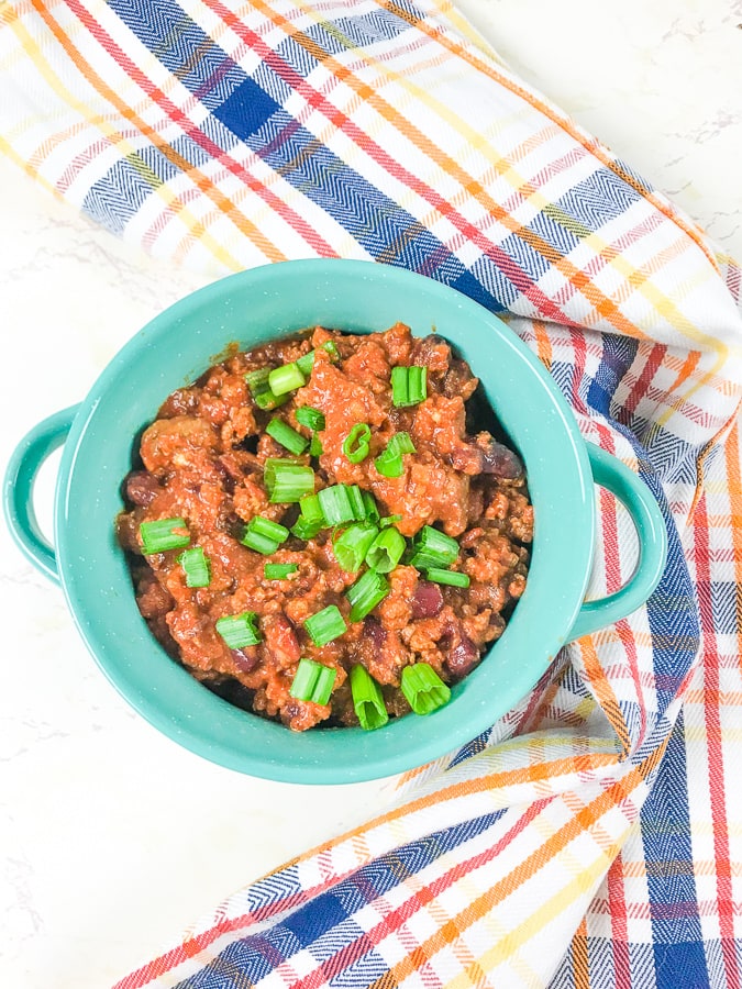 A turquoise soup bowl filled with instant pot beef chili.