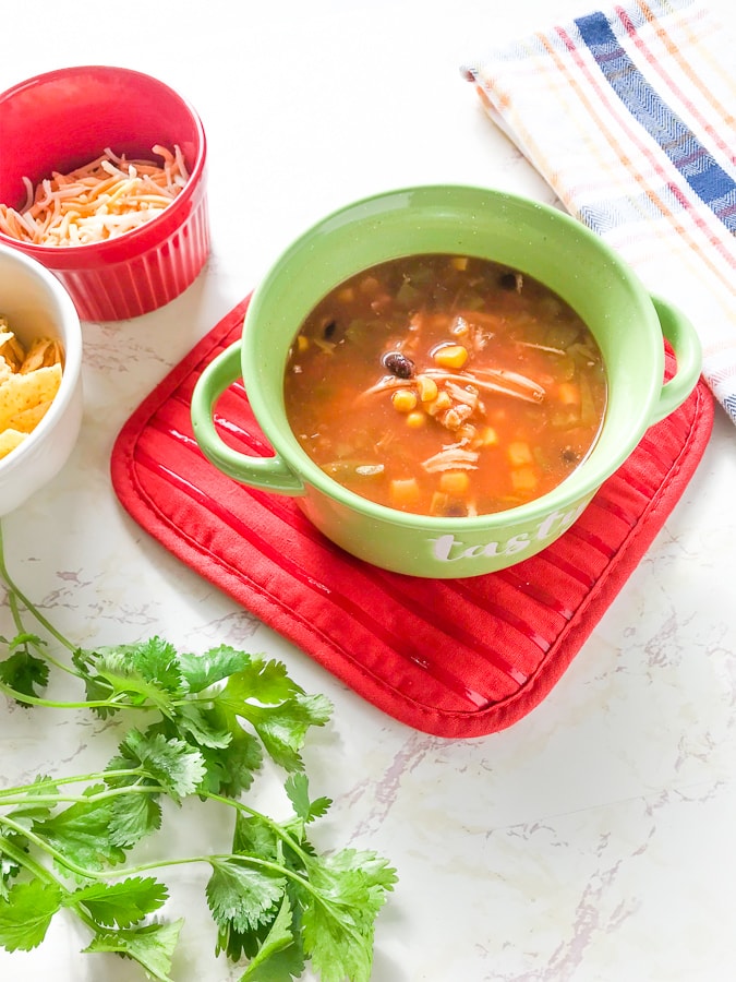 The finished instant pot chicken tortilla soup recipe show in a green soup bowl.