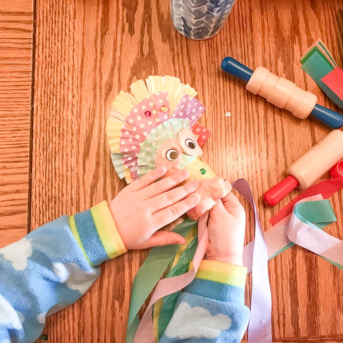 A child's hand holding a handmade dragon.