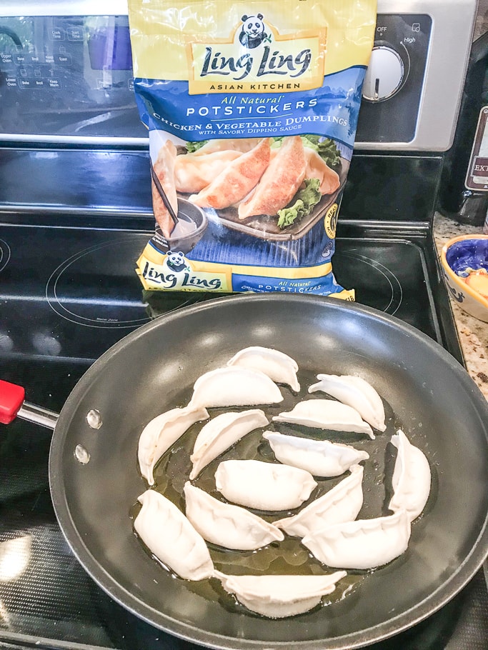 Frozen pot stickers in a large skillet.