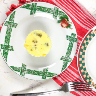 An instant pot egg bit on a white and green plate next to a red striped towel.