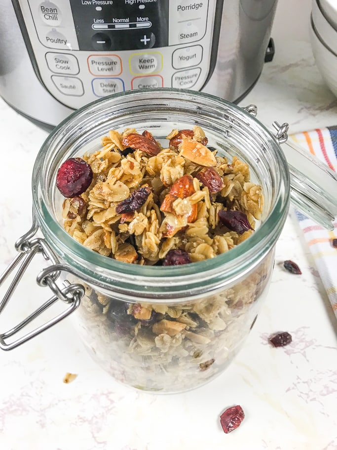 A close up of instant pot granola made with rolled oats, almonds, and dried cranberries