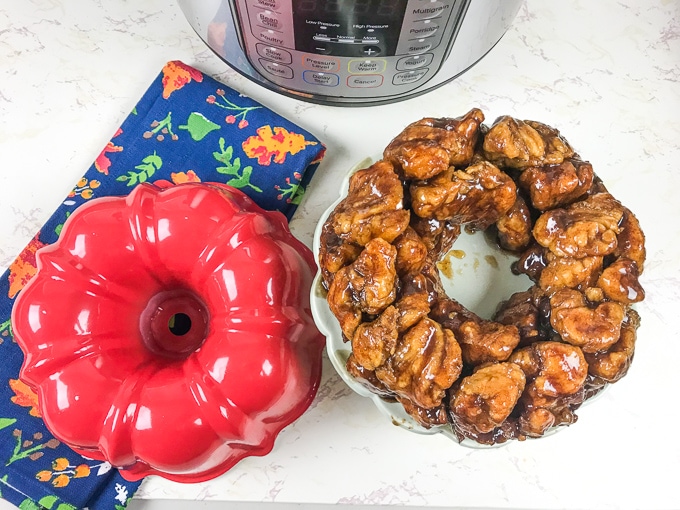 A red bundt pan next to a batch of monkey bread and an instant pot.