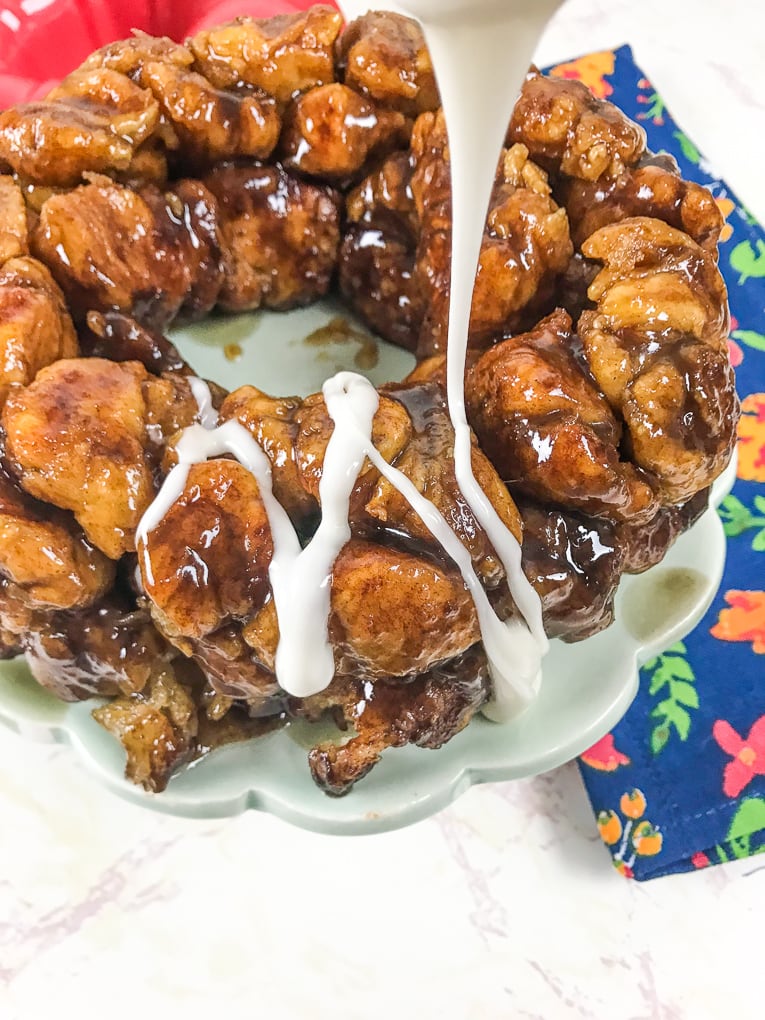 Vanilla icing being drizzled on top of instant pot monkey bread.